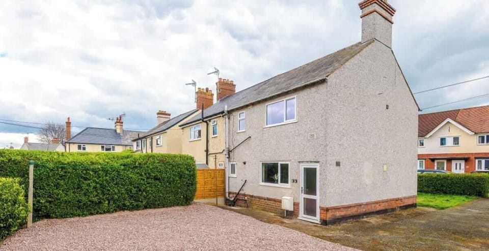 A neat and welcoming end-terrace home with a private driveway and side access.
The property features a gravel parking area and a well-maintained exterior.
Situated in a quiet residential street, ideal for families or contractor stays.