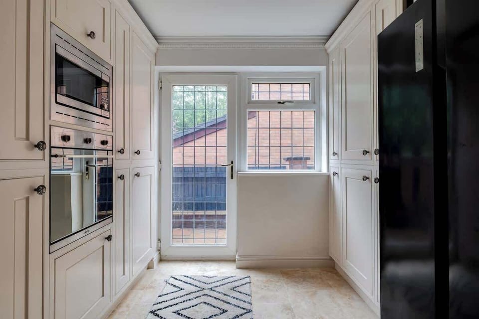 Compact yet fully functional space with modern cabinetry, built-in oven, and direct outdoor access — ideal for light cooking or quick meals.