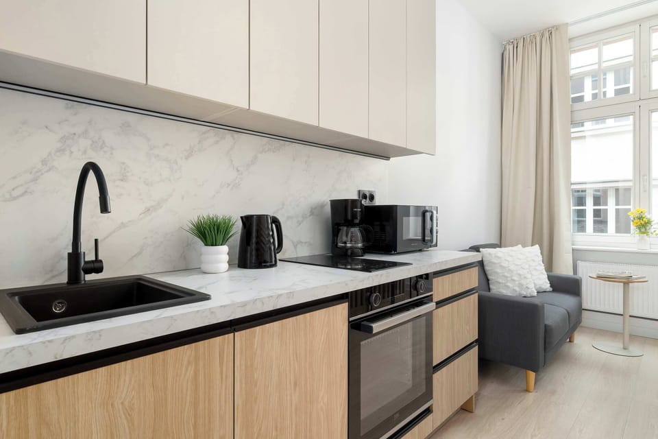 A close view of the kitchen with sink, stovetop, and clean minimalist cabinetry.