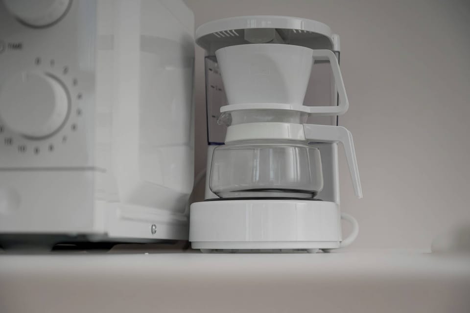 A close-up of a coffee machine placed in a kitchen area. It highlights convenience for daily coffee preparation.