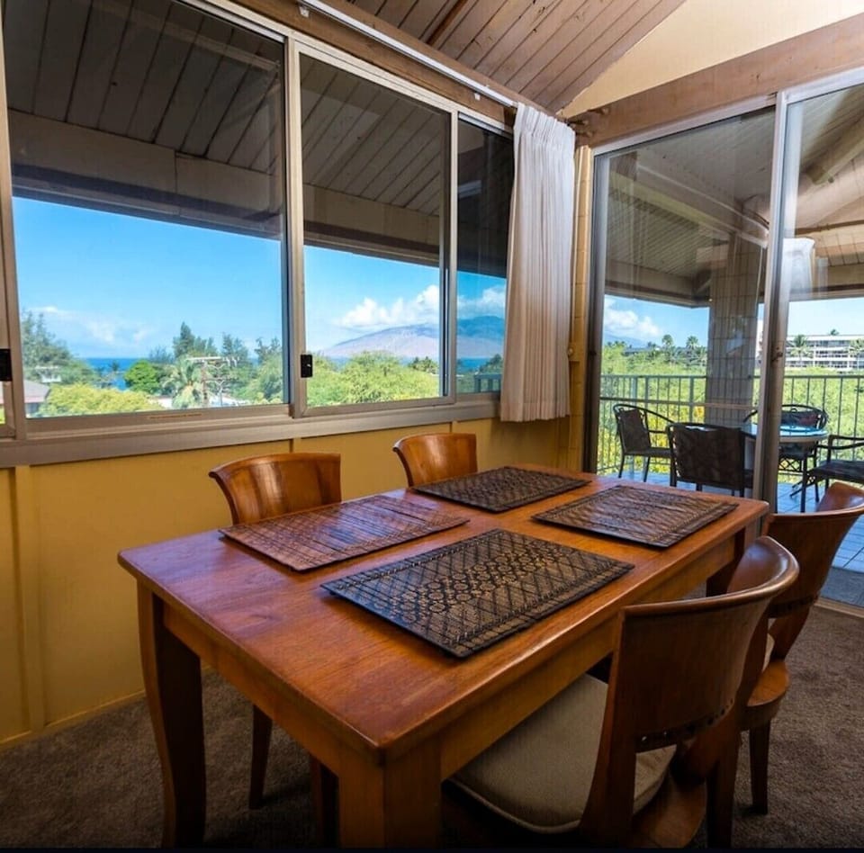 Koa wood dining table with seating for 6, with the lanai entrance.