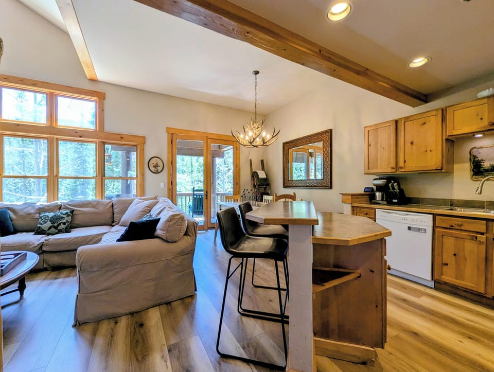 Unwind in your open-concept retreat with soaring beamed ceilings, cozy seating, and a fully equipped kitchen perfect for mountain getaways.