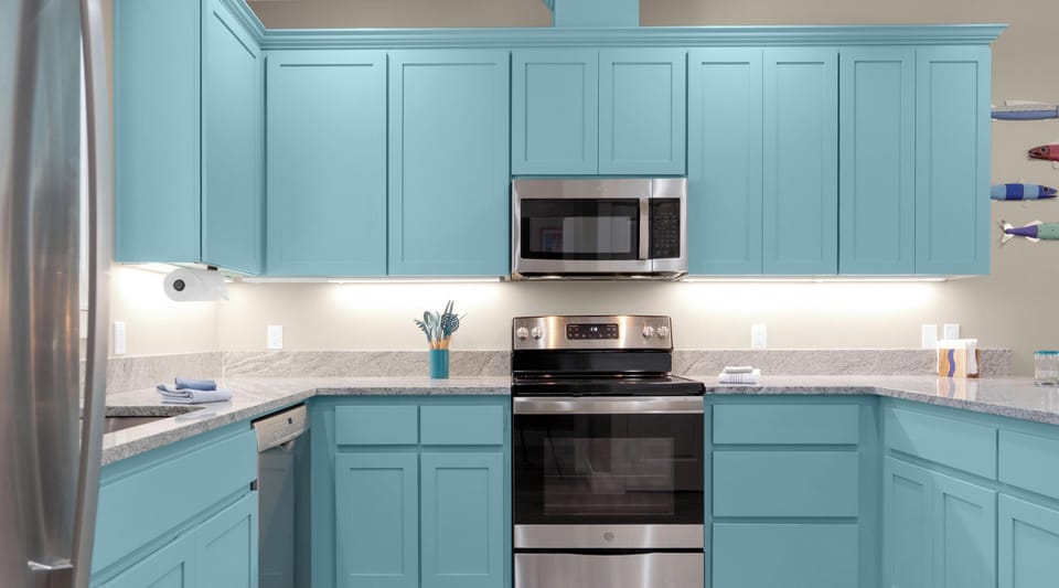Your fully equipped kitchen features charming turquoise cabinets and granite countertops, perfect for preparing meals during your stay.