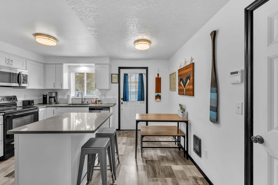 Your fully equipped kitchen features modern appliances, sleek countertops, and a breakfast bar where you can enjoy morning coffee before exploring the mountains nearby.