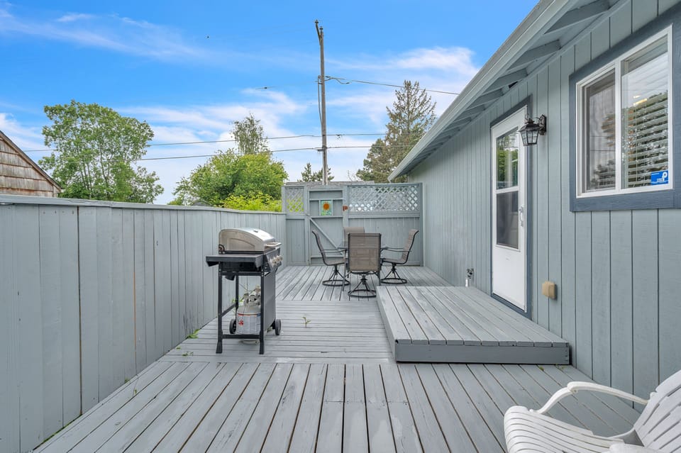 Picture yourself grilling up a feast while relaxing at this spacious deck with comfortable seating, perfect for soaking up the sun and enjoying outdoor meals in your private retreat.
