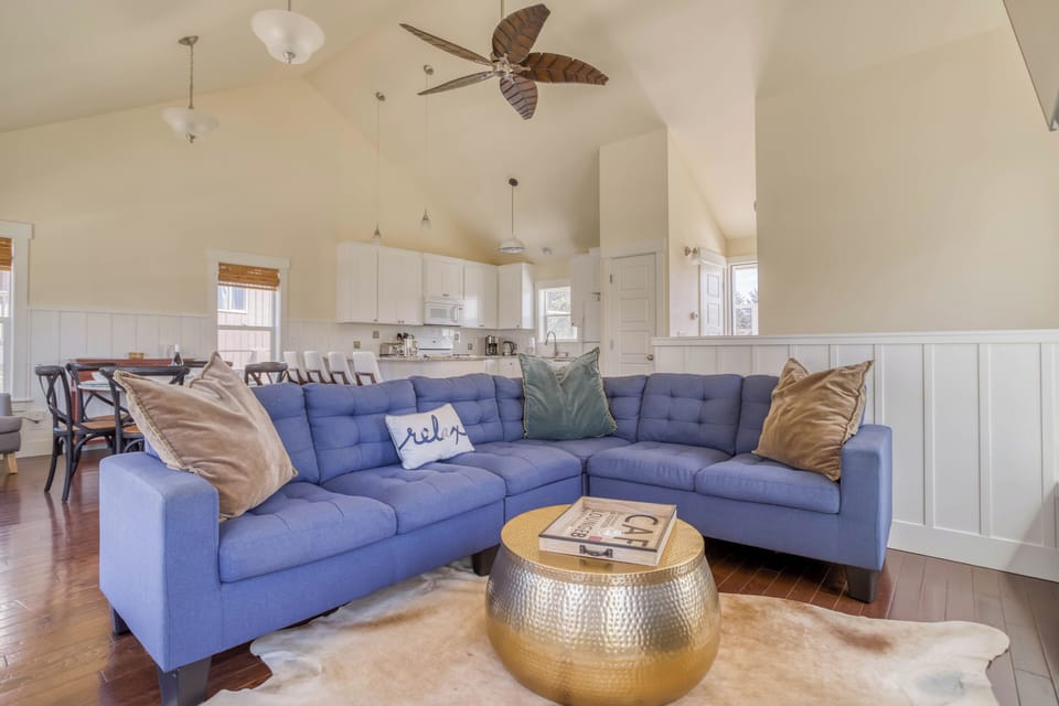Sink into the plush blue sectional and unwind. Vaulted ceilings and coastal touches create your perfect retreat, where relaxation comes naturally.