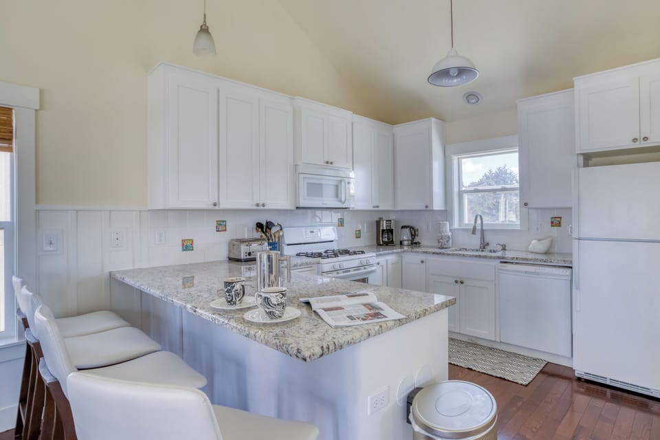 Step into your spacious, sun-filled kitchen where gleaming granite counters and crisp white cabinetry invite you to cook and gather around the breakfast bar.