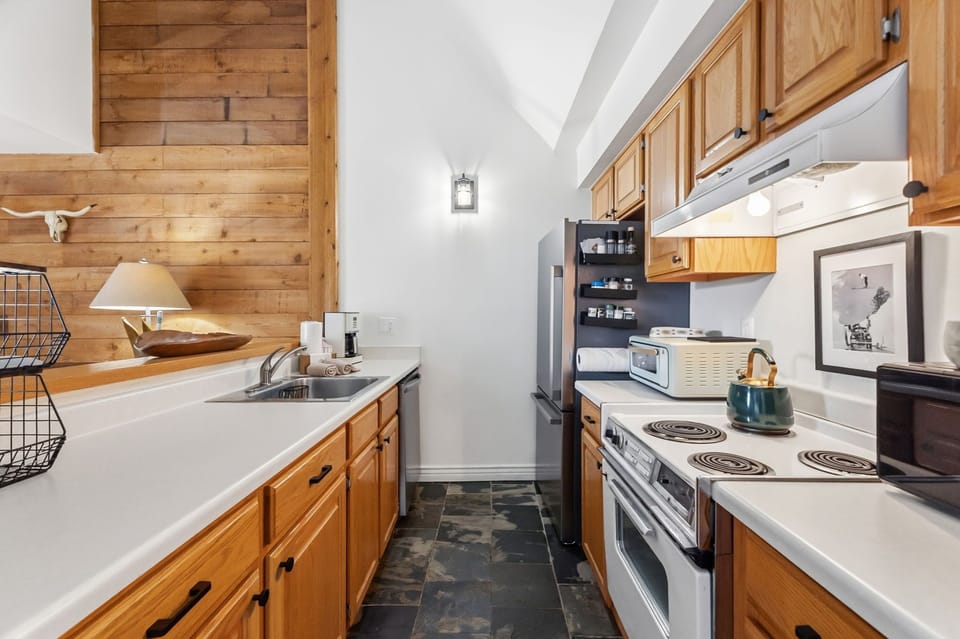 Your mountain cabin kitchen blends rustic charm with modern convenience—warm wood cabinets and cozy accents create the perfect space for preparing meals.