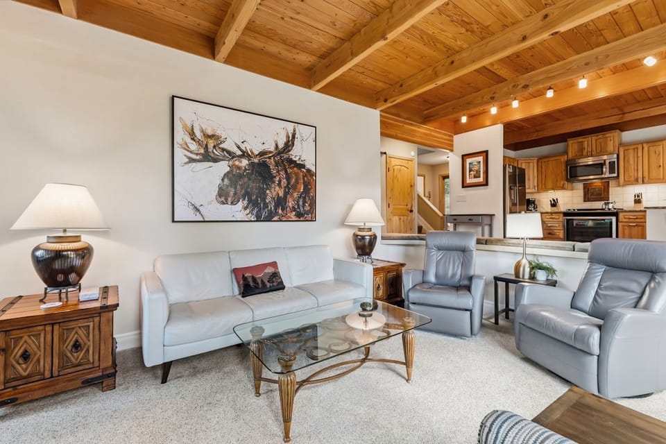 Sink into plush seating beneath soaring wood-beamed ceilings that create an airy, cabin-like charm. Warm natural light and thoughtful touches make this your perfect mountain retreat.