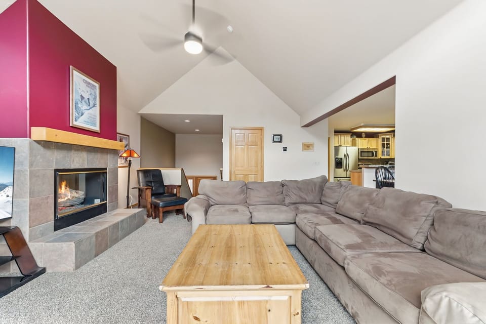 Relax in your spacious living room with soaring ceilings, cozy fireplace, and plush sectional sofa perfect for gathering.