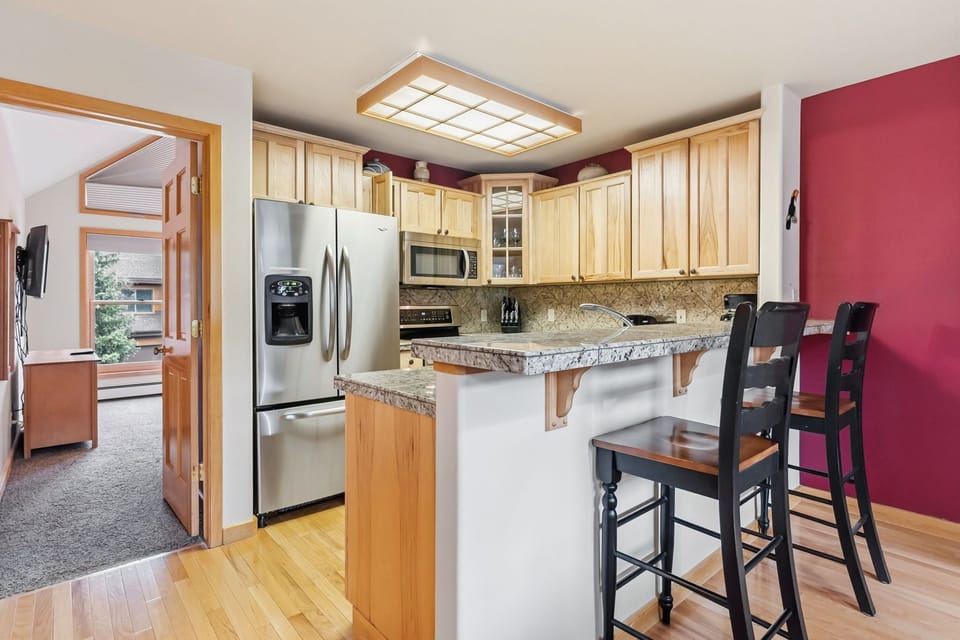 Your spacious kitchen features granite counters, stainless appliances, and a breakfast bar perfect for morning coffee.