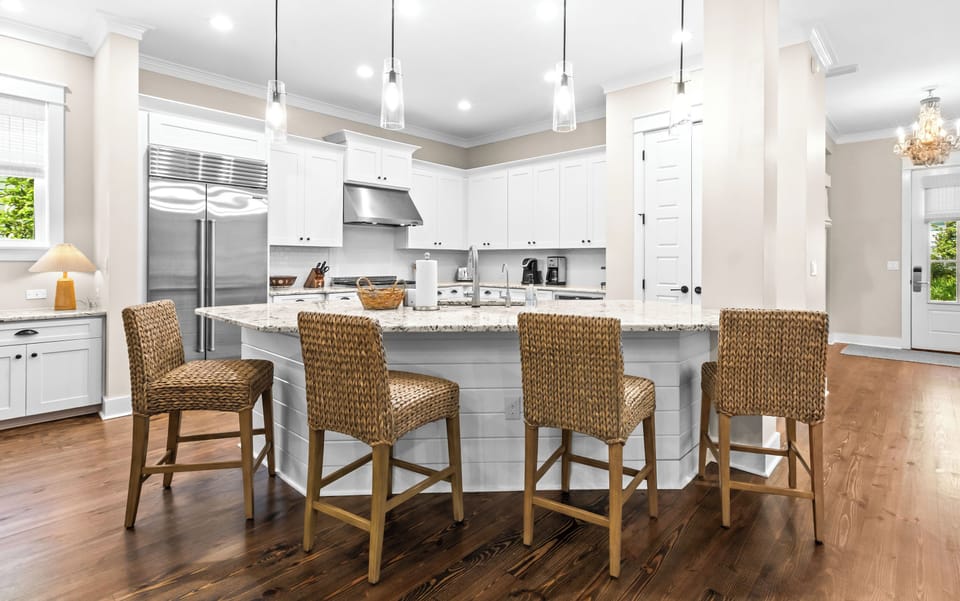 Coastal-chic woven seating invites morning coffee or evening conversations in this bright culinary haven.