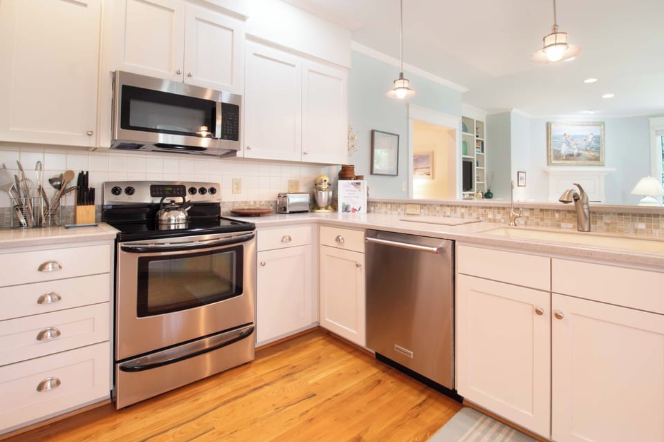 Step into your bright, fully-equipped kitchen with stainless steel appliances, ample counter space, and coastal charm—perfect for preparing morning coffee or home-cooked meals during your stay.