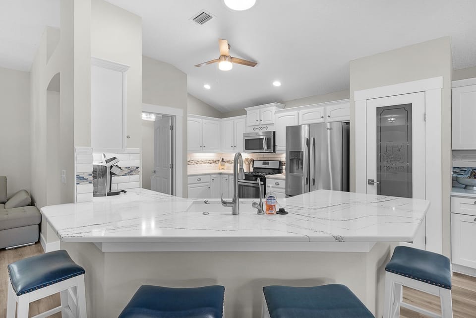 Gather around this sleek marble island where you'll find everything you need to create memorable meals. The modern kitchen features stainless steel appliances and ample counter space for your culinary adventures.