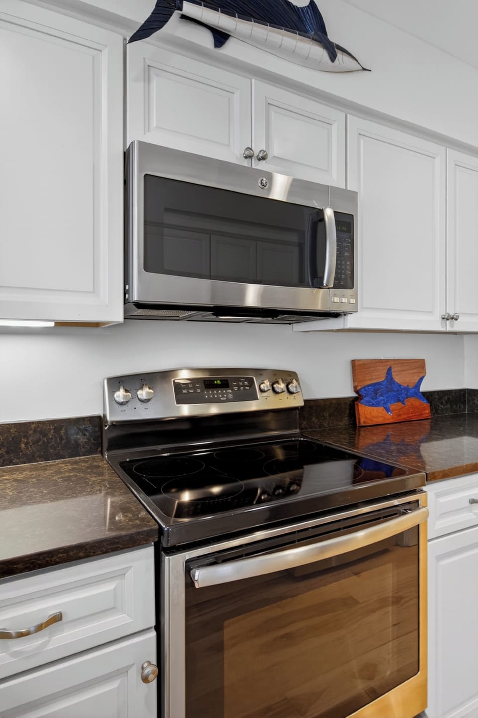 Your fully equipped kitchen features a modern glass-top stove, over-range microwave, and sleek granite countertops—perfect for preparing home-cooked meals during your stay.