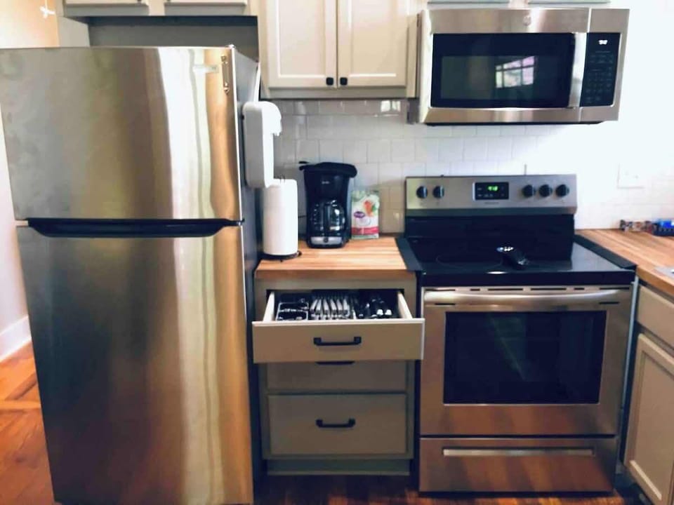 A fully stocked, stainless steel kitchen with cookware, silverware, and tupperware... all the wares for your cares, everywhere (see what I did there)