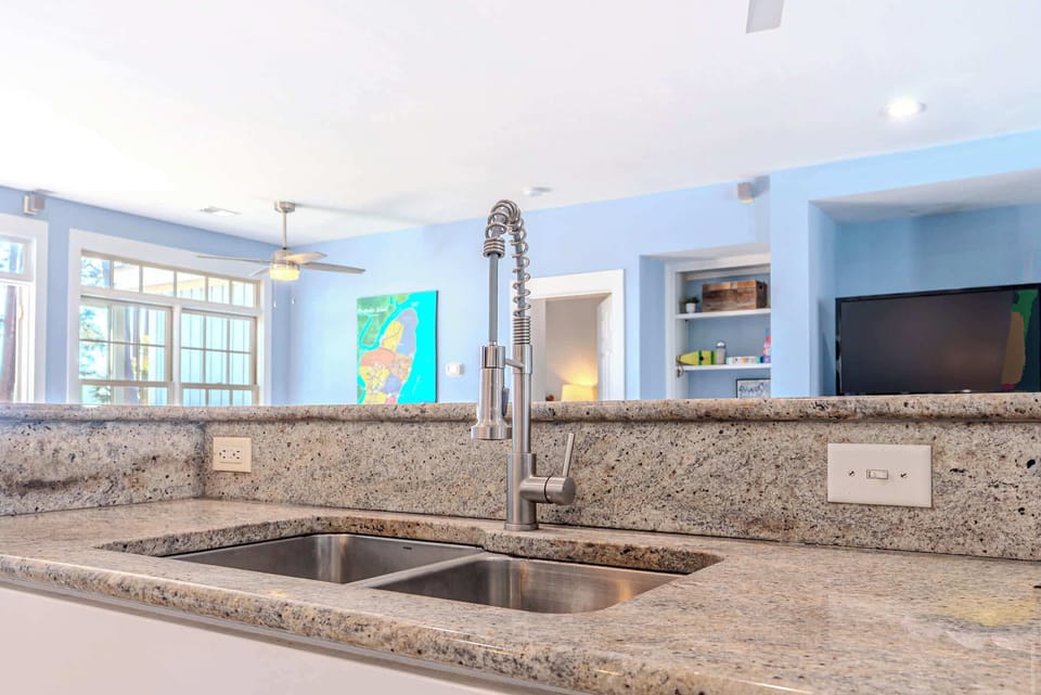 Chef-grade spring faucet meets granite perfection at 152 Ave of Oaks — where Hilton Head luxury flows effortlessly into every detail of your island escape.
