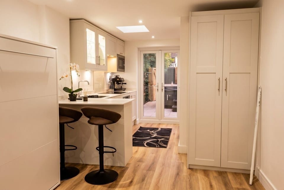 Modern kitchen with breakfast bar and patio doors to the garden.