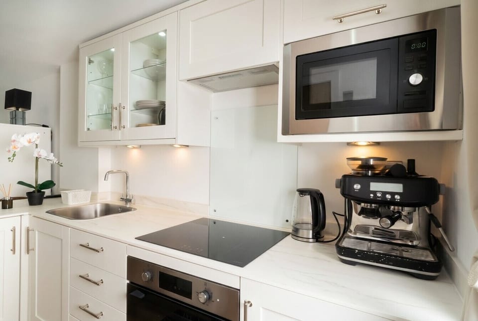 Fully equipped kitchen with oven, hob and barista coffee setup.