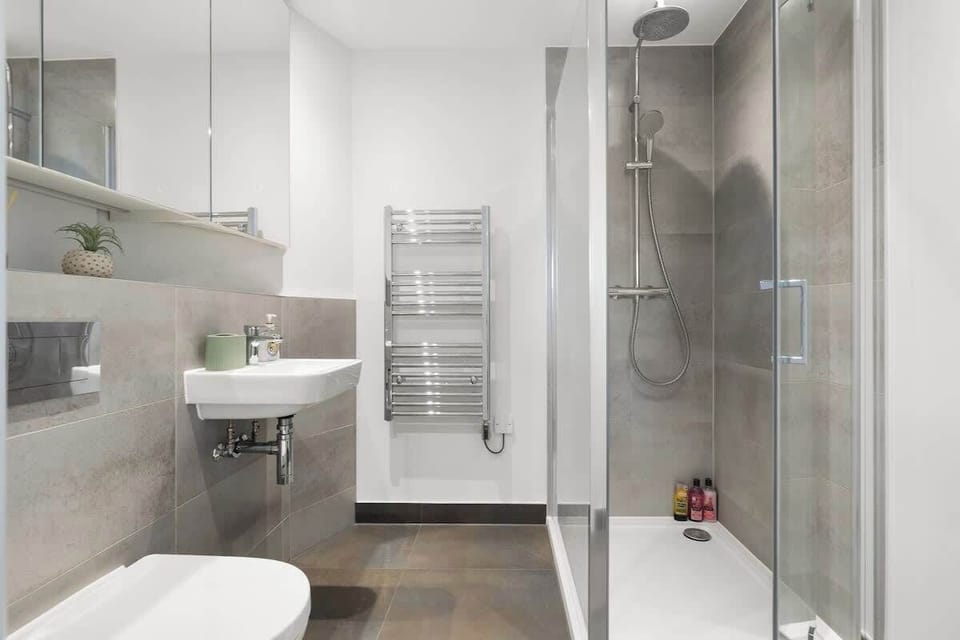 Bathroom w/ glass shower, sink & clean tile finishes