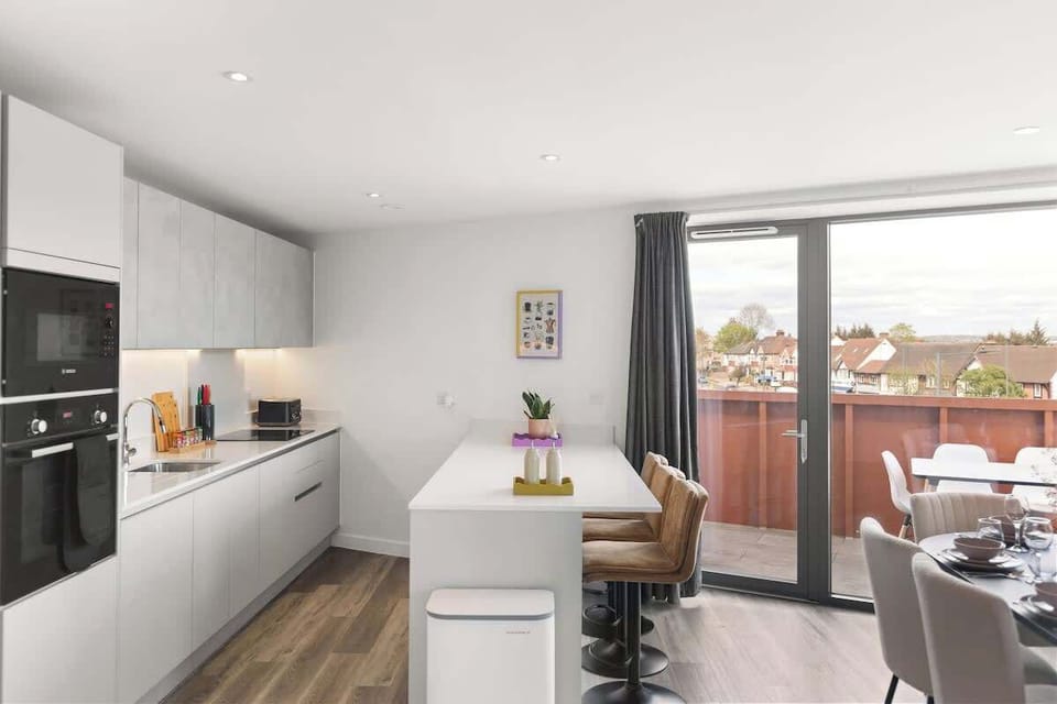 Sleek kitchen w/ white cabinetry, modern finishes & clean layout