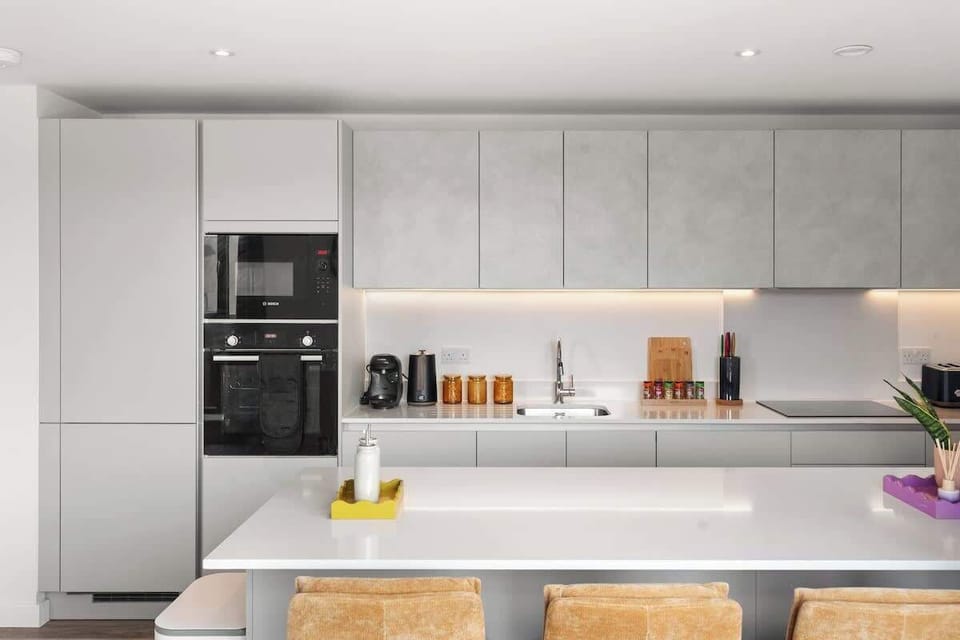 Modern kitchen w/ built-in appliances, smooth counters & bar seating