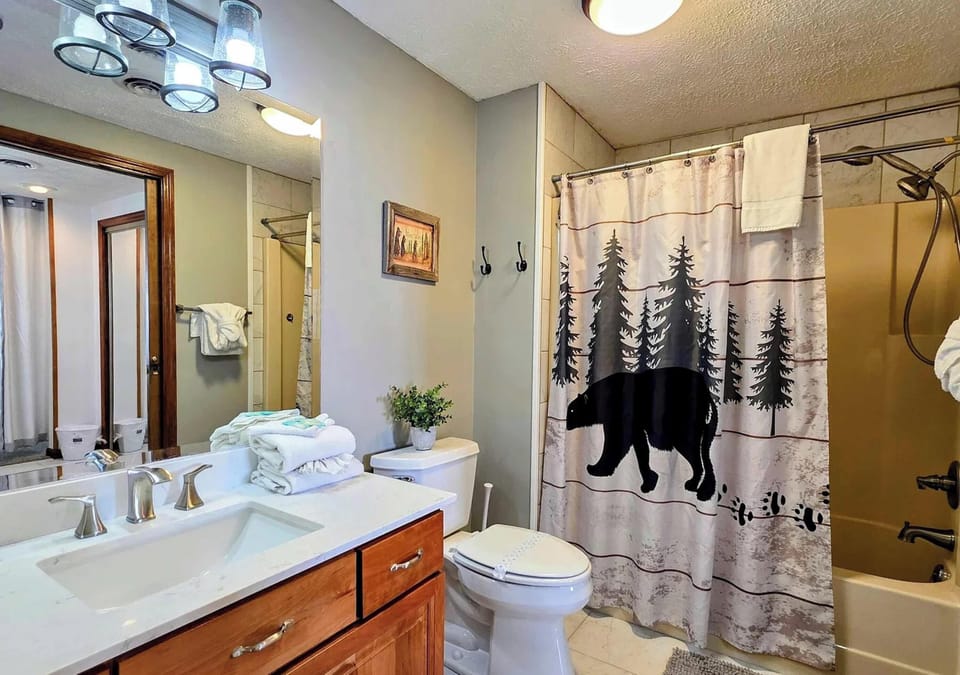 Ensuite bathroom w/ single vanity and shower/tub combo