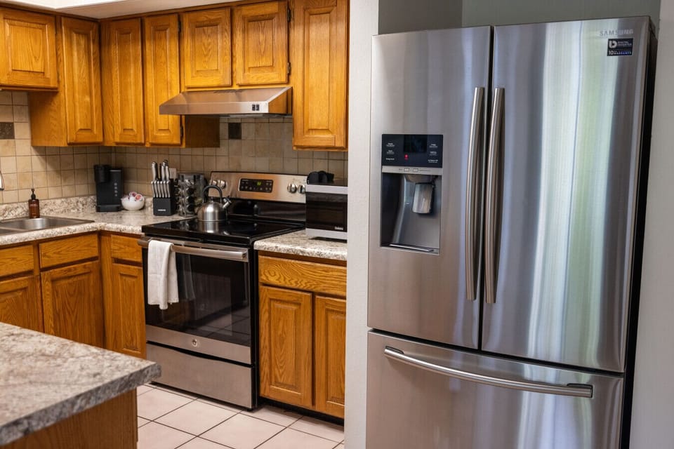 Spacious kitchen area with a large fridge and stove