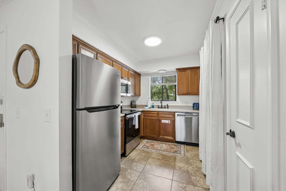 Fully equipped kitchen with stainless steel appliances, ample cabinet space, and peaceful greenery views. Thoughtfully stocked and designed for convenience, making meals feel just like home.