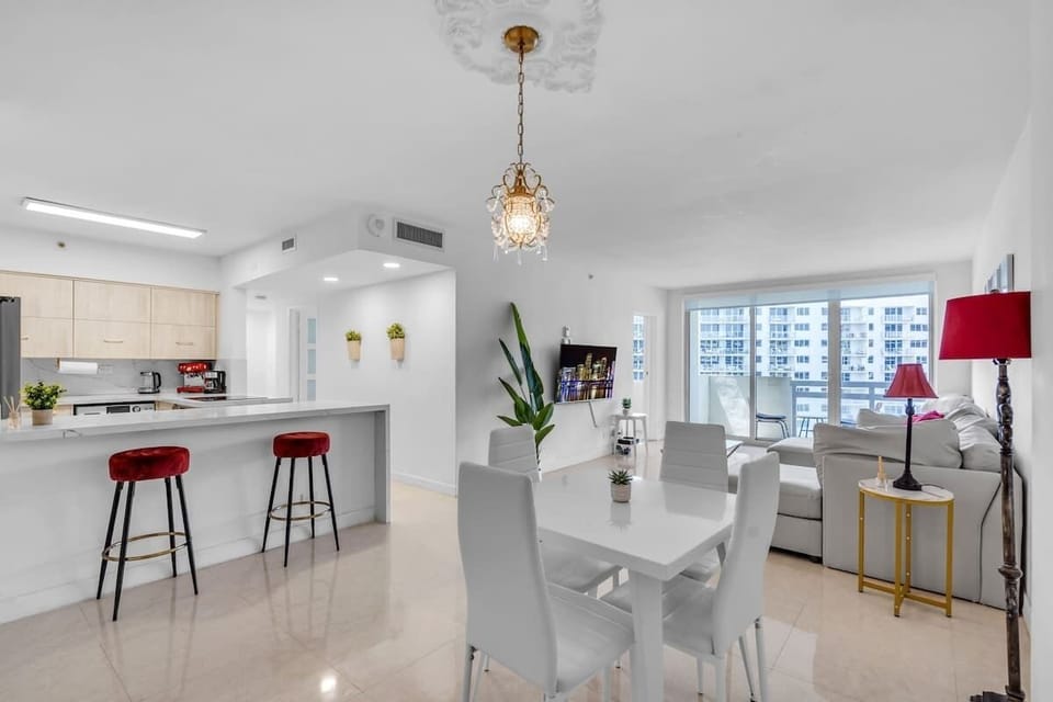 Fully equipped modern kitchen with premium appliances, breakfast bar seating, and elegant pendant lighting — perfect for cooking in