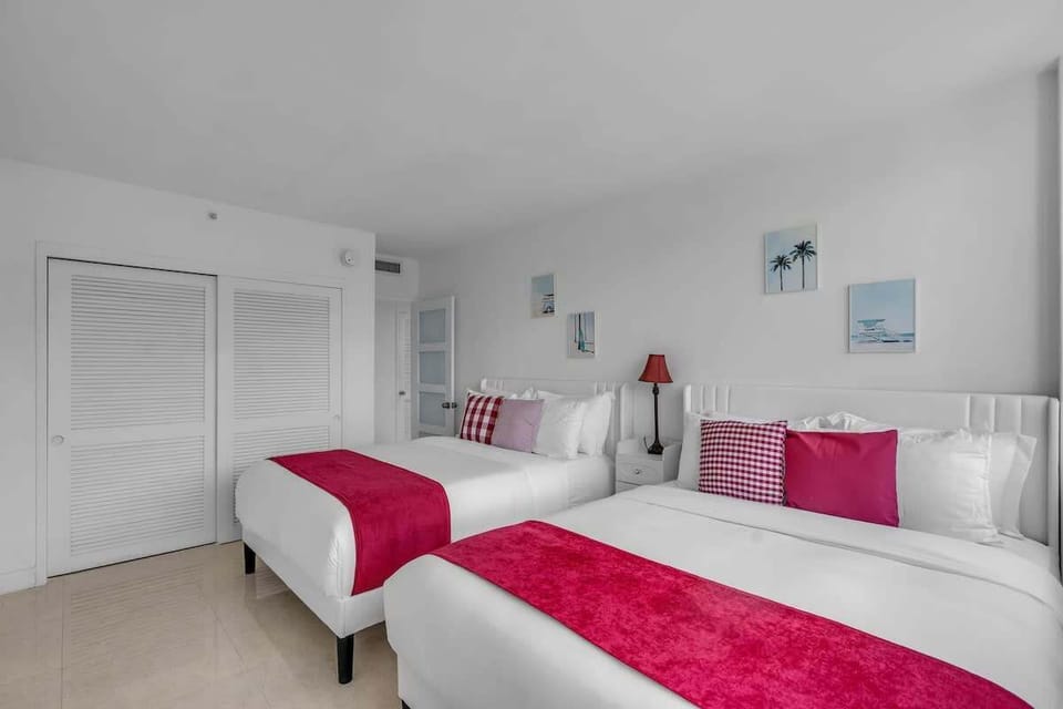 2 Queen bedroom area with two beds, vibrant red accents and gorgeous Miami views — ideal for families or groups