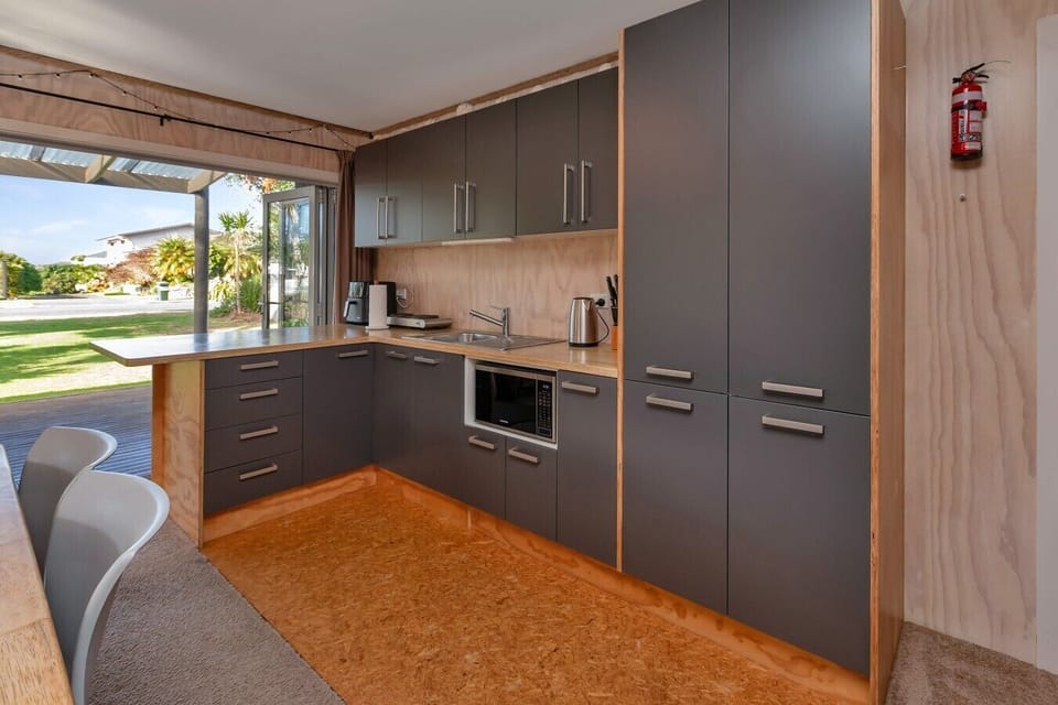 Kitchen includes a portable double electric hotplate, mini electric oven, microwave, and airfryer (please note there is no conventional oven or stove).