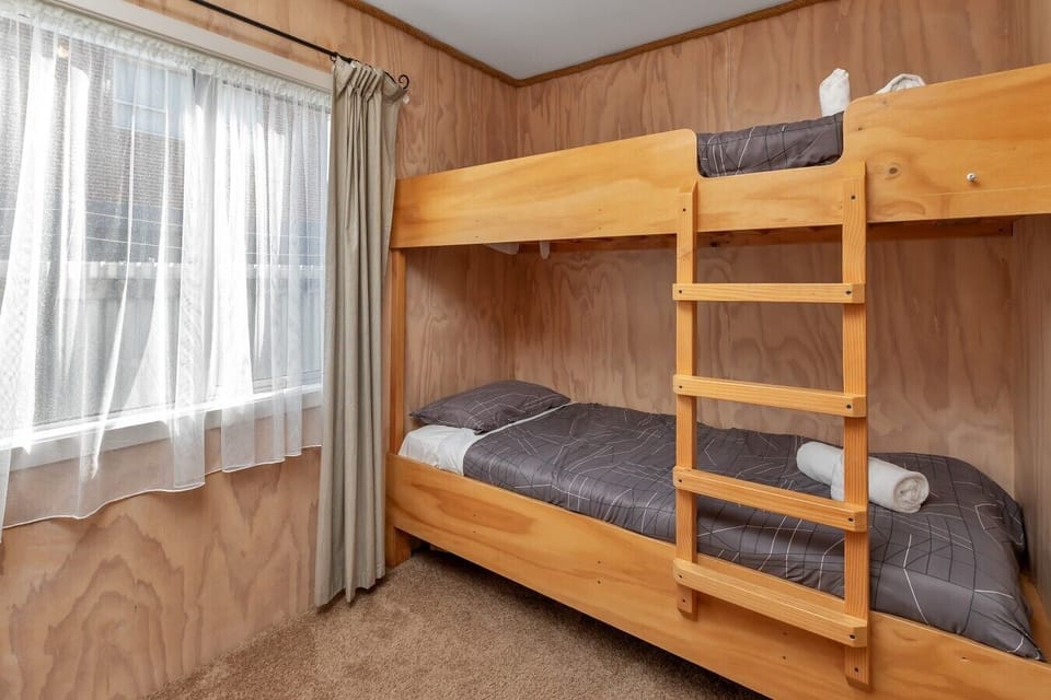 Bedroom 2 features two sets of sturdy, solid timber single bunk beds