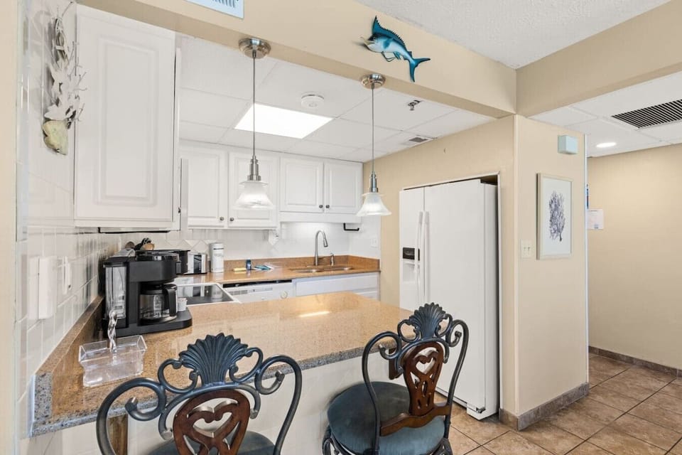 Fully equipped kitchen with granite countertops and bar seating for casual dining and morning coffee.