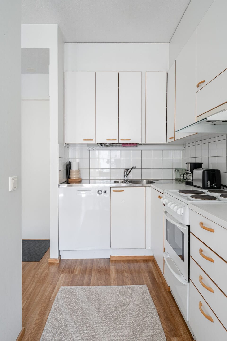 Clean and functional kitchen layout with a dual stainless steel sink, tile backsplash, and plenty of cabinet storage.