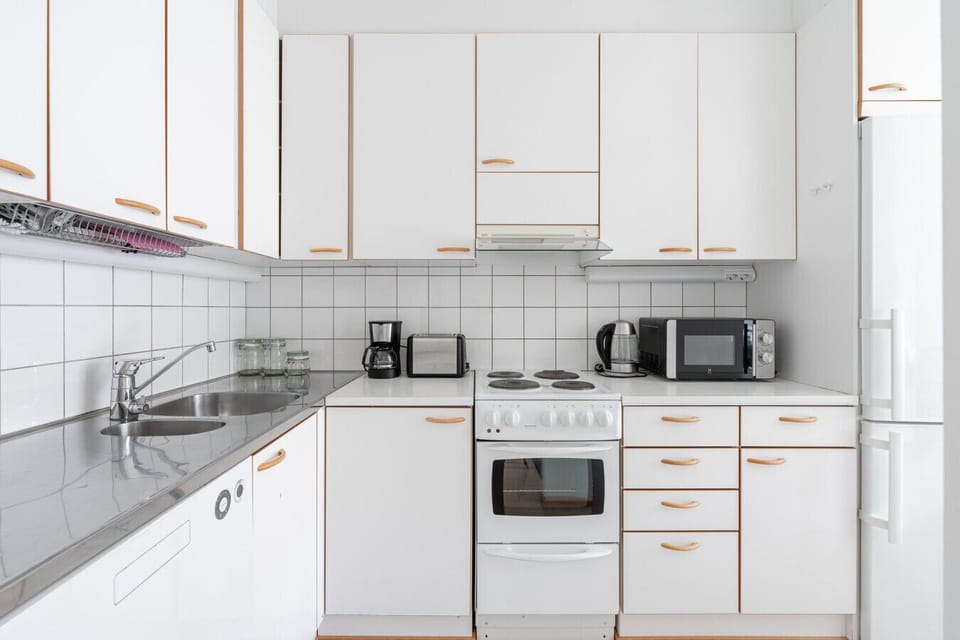 A closer look at the bright kitchen, featuring a stovetop, oven, microwave, coffee maker, and toaster to handle all your culinary needs.