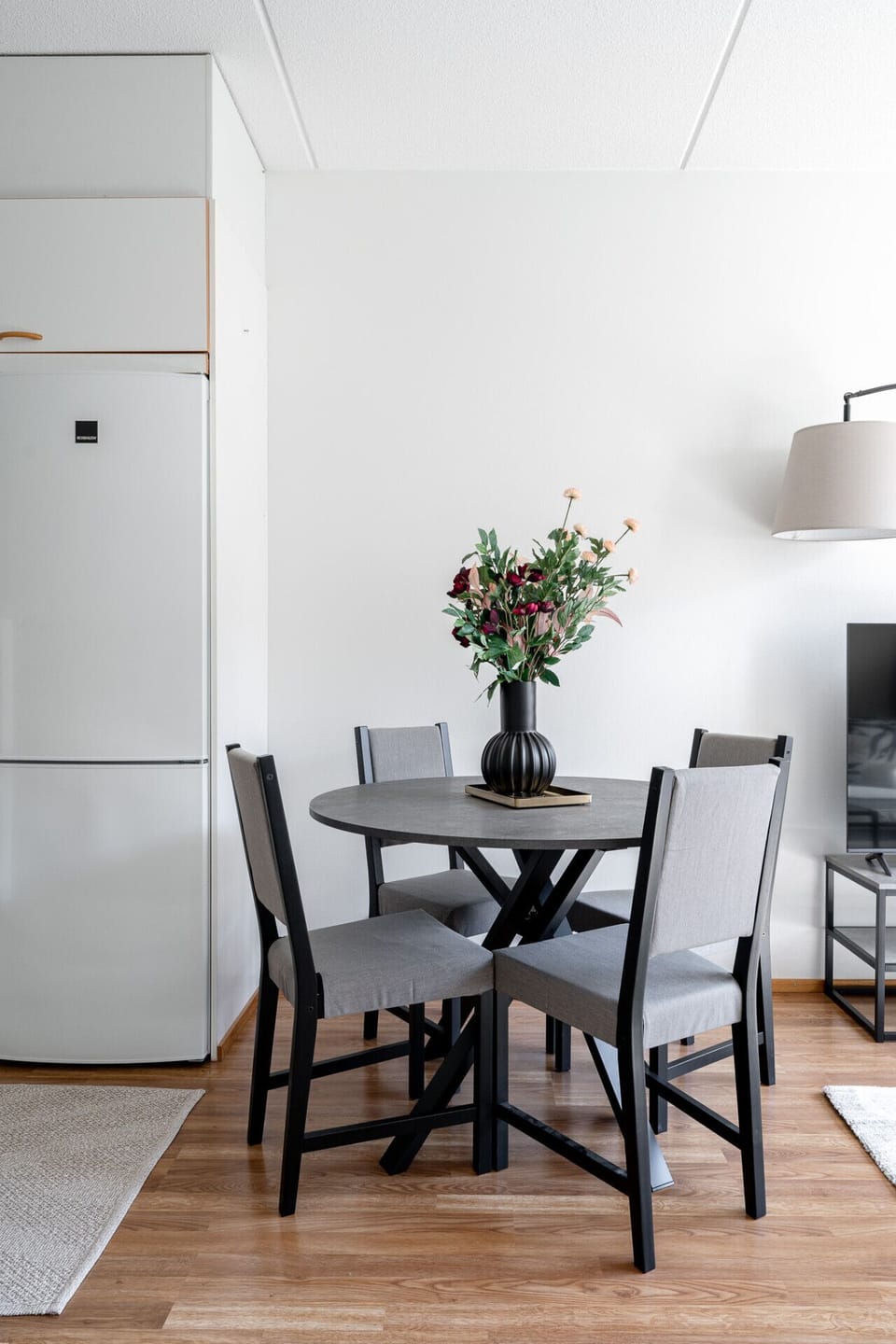 Enjoy home-cooked meals or a morning coffee at this sleek dining table, beautifully styled with fresh floral accents.
