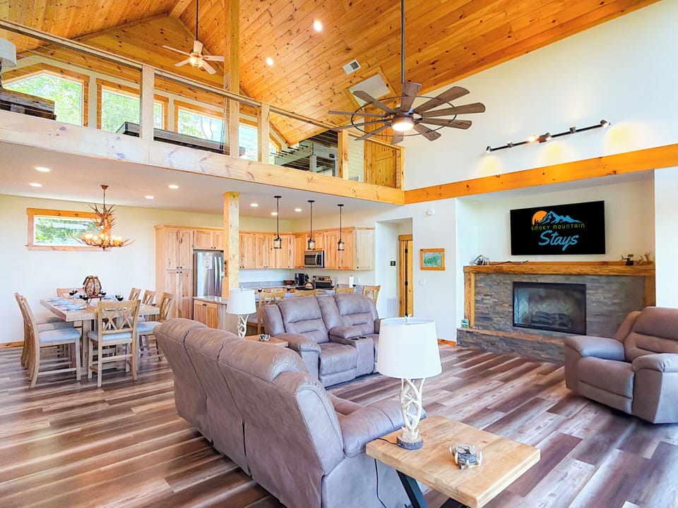 The living room features a 65" Smart TV, electric fireplace for cold nights, and plenty of comfy seating for your group.