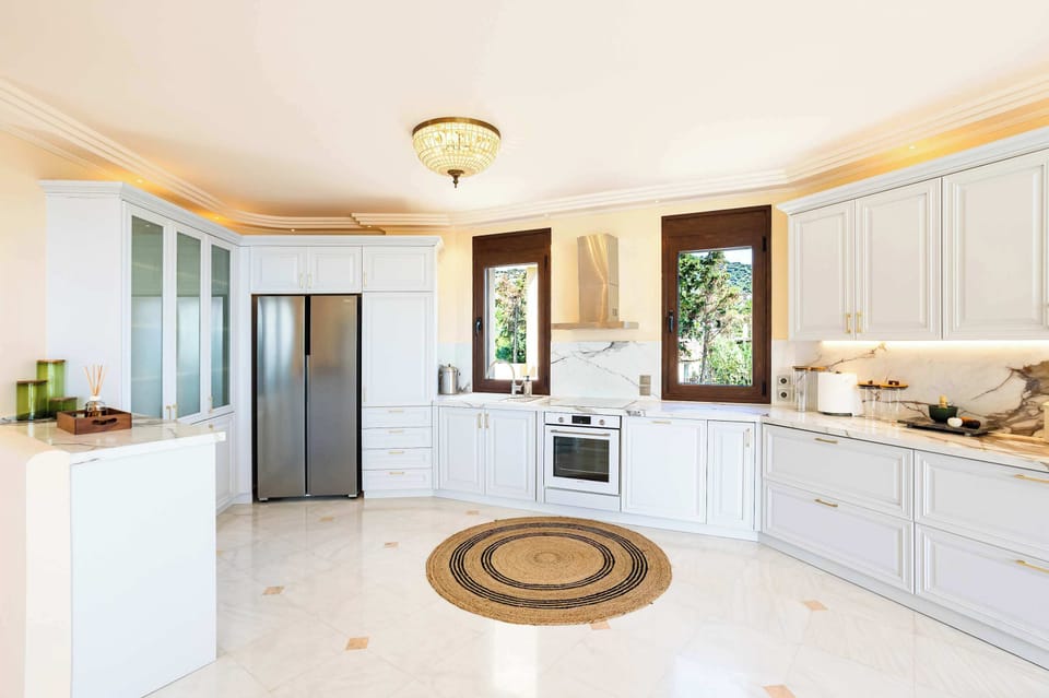 The fully equipped kitchen combines clean lines, generous preparation space, and direct access to the outdoor areas for easy everyday living.