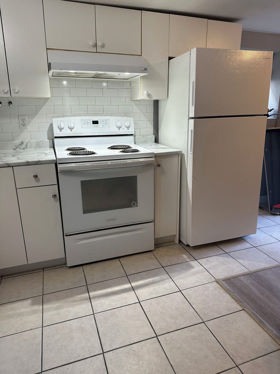 Full kitchen with fridge, freezer, stove , microwave and dining table and chair