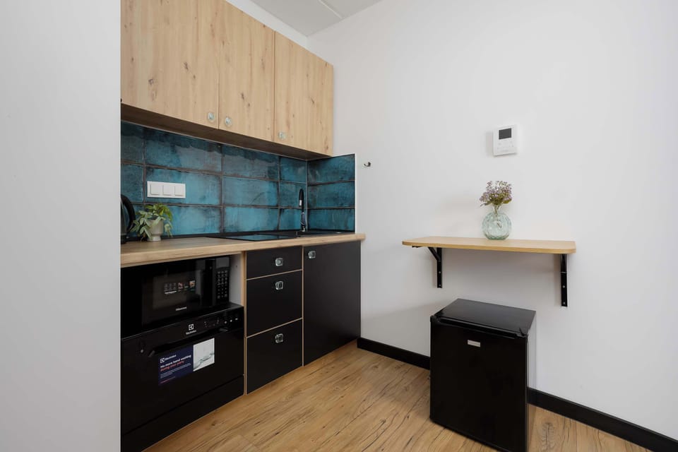 Stylish kitchenette with wooden cabinets and blue tile backsplash
