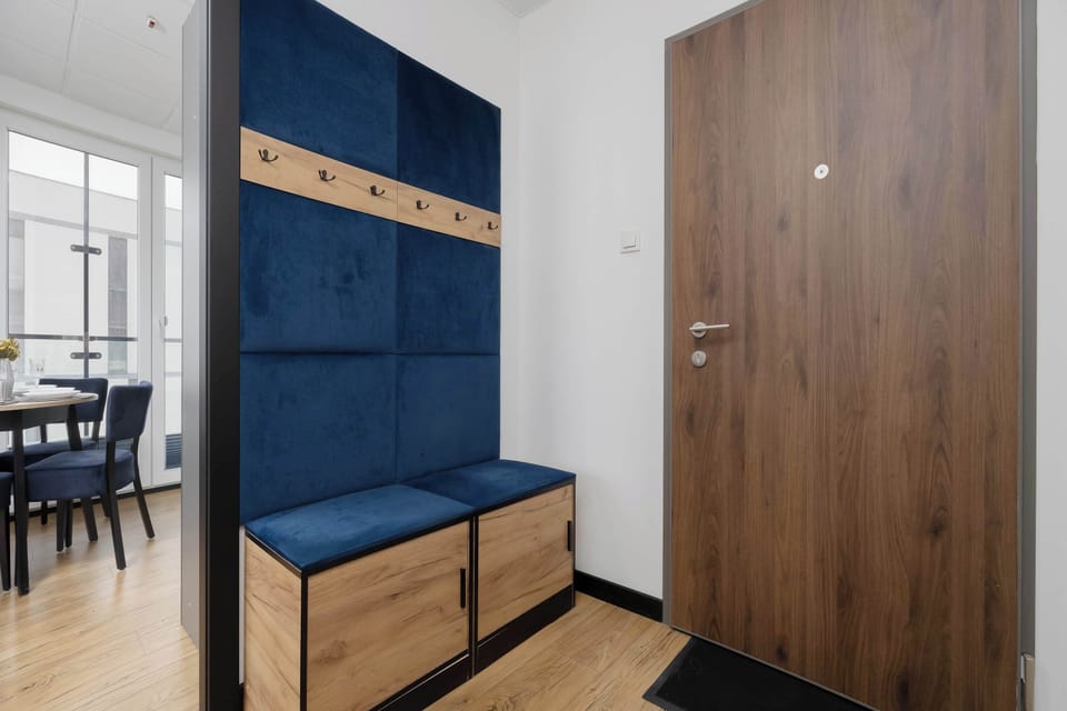 Stylish hallway with blue upholstered bench and wooden wardrobe