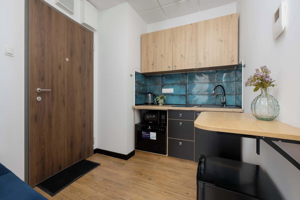 Stylish kitchenette with built-in wardrobe and wood accents