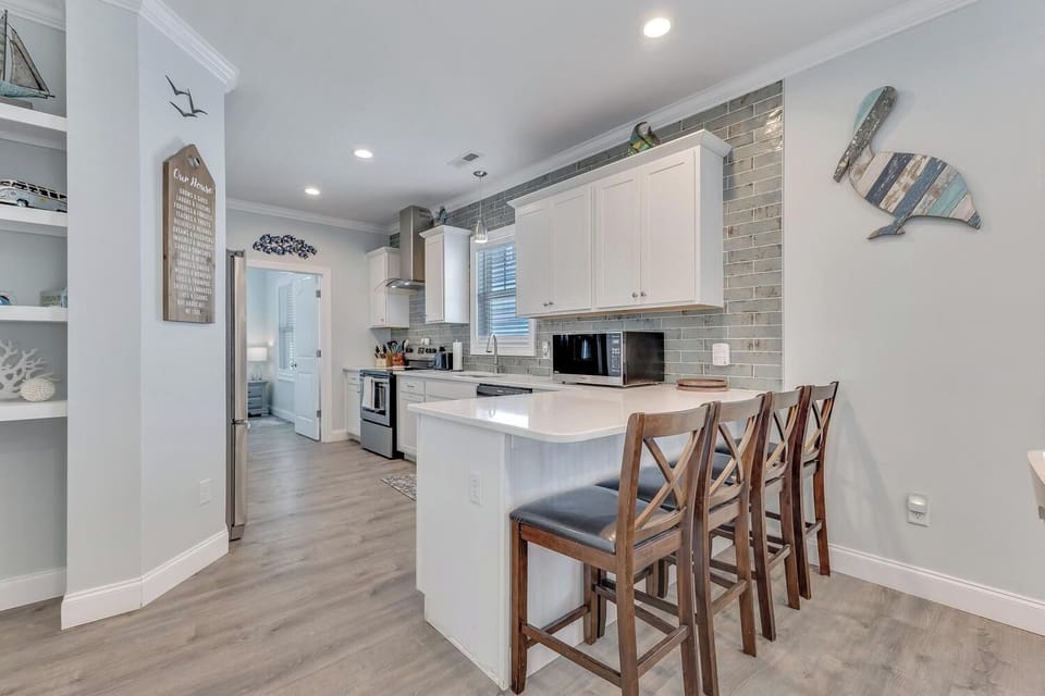 Your coastal-inspired kitchen welcomes you with crisp white cabinetry, gleaming countertops, and a convenient breakfast bar perfect for morning coffee or casual meals with loved ones.