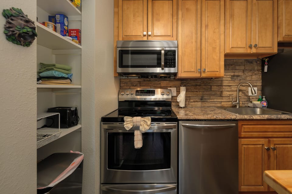 Your fully-equipped kitchen awaits with granite counters, stainless appliances, and a convenient pantry stocked with essentials for your stay.