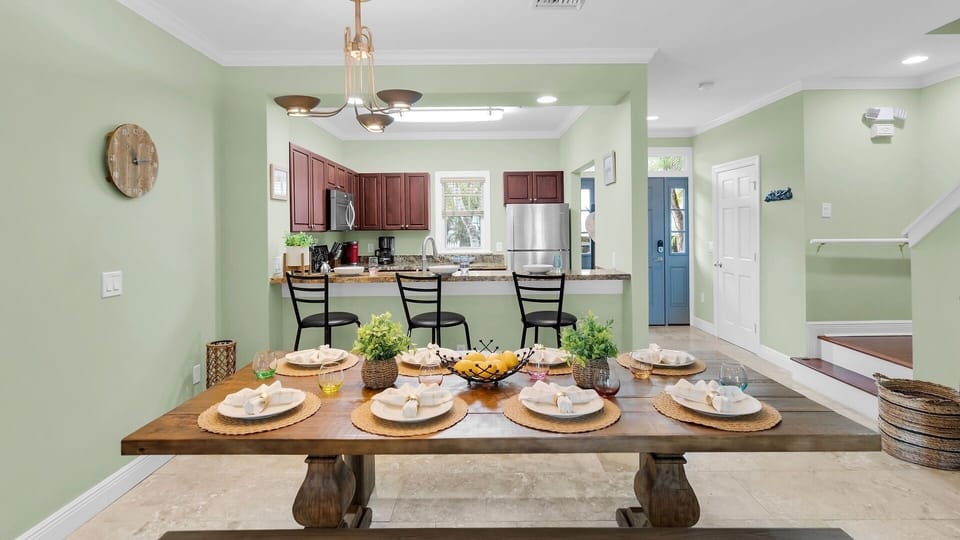 Picture yourself gathering around this spacious dining table, perfectly set for memorable meals with loved ones, opening seamlessly to your fully equipped kitchen for effortless hosting.