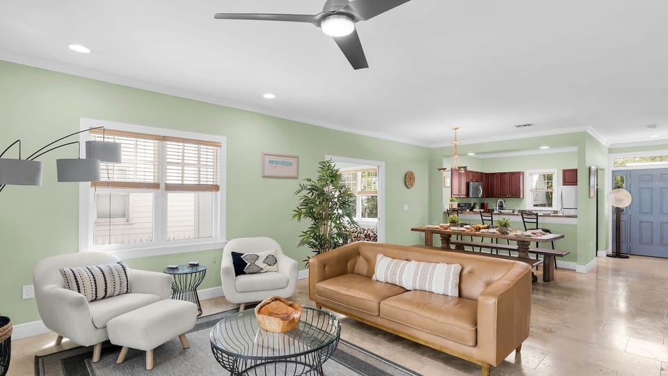 Sink into the leather sofa, enjoy the cool breeze from your ceiling fan, and savor the open flow into your fully-equipped kitchen—your perfect home base awaits.