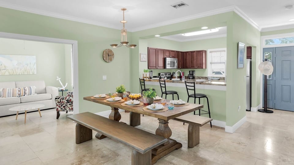 Gather around this inviting dining table where your vacation memories are made. The open layout flows seamlessly to a fully equipped kitchen, perfect for home-cooked meals together.