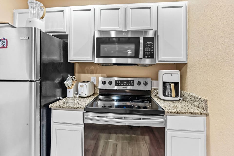 Discover a stylish kitchen with stainless steel appliances and beautiful granite countertops, ideal for meal prep. The bright cabinetry and modern design create a warm, inviting space for your culinary adventures.