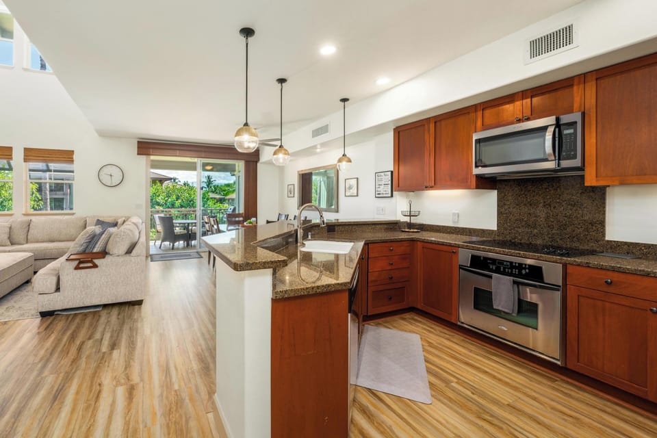 Step into your sunlit open-concept living space, where warm wood tones and modern finishes create the perfect home away from home. The fully equipped kitchen with granite countertops flows seamlessly into your cozy living area, opening to your private outd
